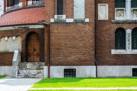Fragment of the cathedral in the city of Szeged in Hungary with a door and stone steps.
