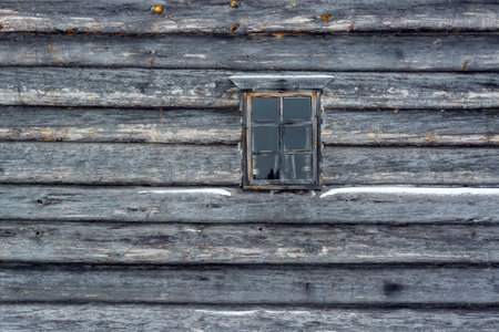 Small rectangular window against a wall of old, grayed logs. From the Window of the World series.の写真素材