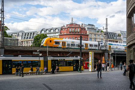 Berlin, Germany, July 20: Cityscape with a yellow tram and high-speed train on a railway overpass in one of the areas in Berlin on July 20, 2023.のeditorial素材