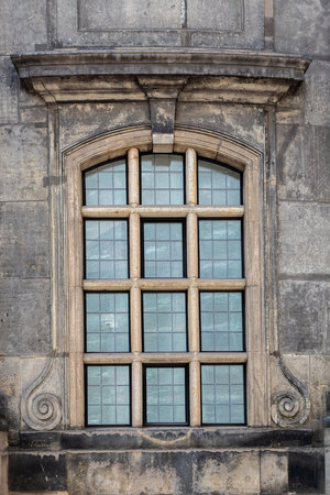 Window of the old Lutheran church Kreuzkirche against the background of a stone wall in the city of Dresden. From the Window of the World series.の写真素材