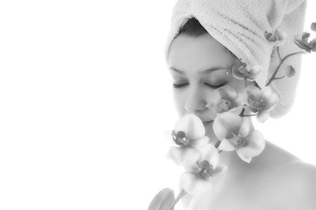 beauty halth and spa wellness isolated young woman face portrait closeup with towel and flower treatmentの写真素材