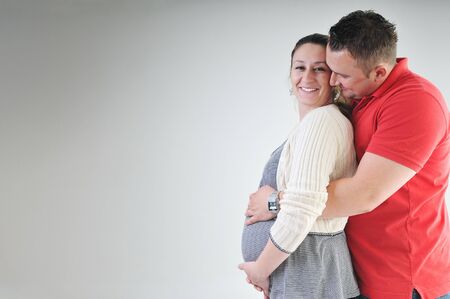 young family couple together in studio isolated on white. happy and waiting for babyの写真素材