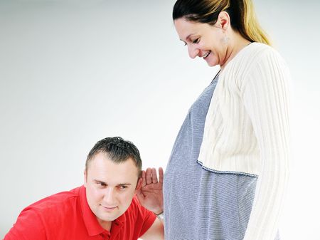 young family couple together in studio isolated on white. happy and waiting for babyの写真素材
