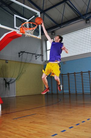 one healthy young  man play basketball game in school gym indoorの写真素材