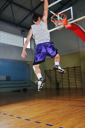 one healthy young  man play basketball game in school gym indoorの写真素材
