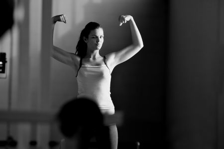 young woman with strong arms rising hands in air and representing their streinght and vitality
