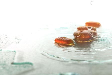 isolated wet zen stones with splashing  water drops  representing concept of natural balance and perfect harmonyの写真素材