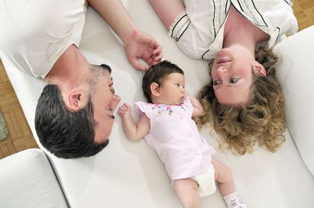 indoor portrait with happy young family and  cute little babby