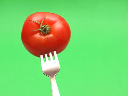 fresh tomato on fork の写真素材