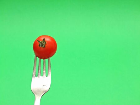 fresh tomato on fork の写真素材