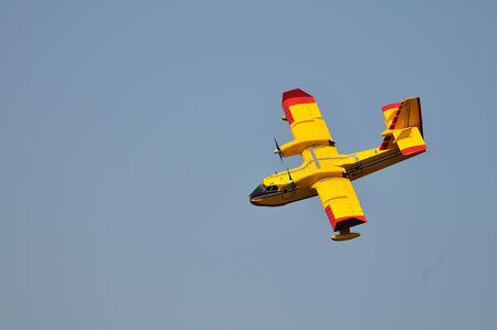 Airplane on sea taking water to drop over fire