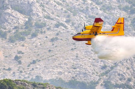 Airplane droping water on fire on islandの写真素材