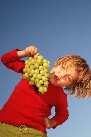 happy girl with grape outsideの写真素材