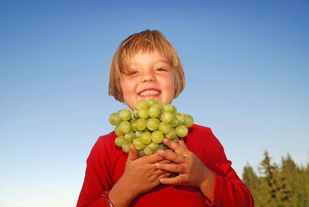 happy girl with grape outsideの写真素材