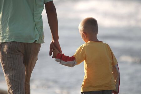 father and son walking on beachの写真素材
