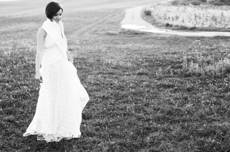 happy young beautiful bride after wedding ceremony event have fun on meadow in fashionable wedding dressの写真素材
