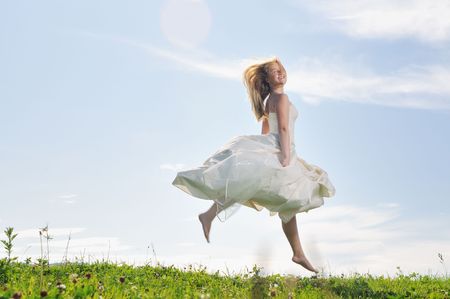 happy young beautiful bride after wedding ceremony event have fun outdoor on meadow at sunsetの写真素材
