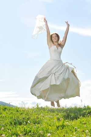 happy young beautiful bride after wedding ceremony event have fun outdoor on meadow at sunsetの写真素材