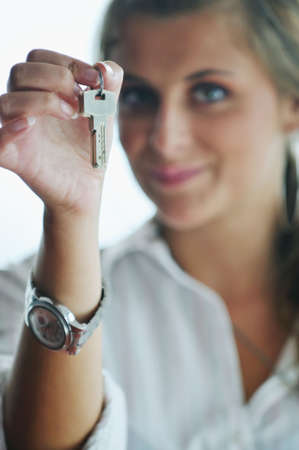 happy young woman throw keys from their apartment and home in ai and representing concept of joy and financial freedomの写真素材