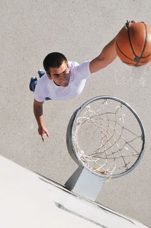 gorup of young boys who playing basketball outdoor on street with long shadows and bird view...
