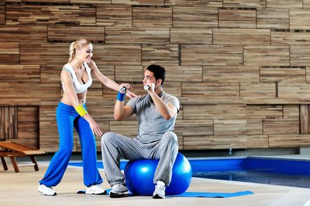 fitness personal trainer on fitness classes supporting group of people and wotrking out together in teamの写真素材