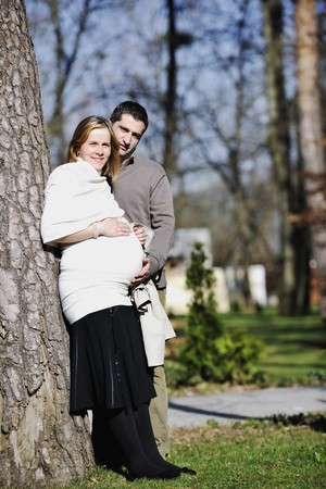 happy young married family couple outdoor in nature have fun and waiting baby and representing young family growth and pregnancy conceptの写真素材