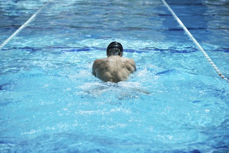 young healthy with muscular body man swim on swimming pool and representing healthy and recreation conceptの写真素材