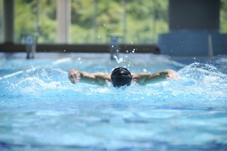 young healthy with muscular body man swim on swimming pool and representing healthy and recreation conceptの写真素材