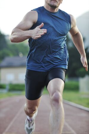 young healthy man run on athletic race sport track and representing concept of sort and speedの写真素材