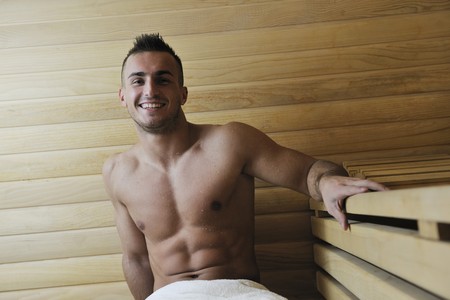 happy good looking and attractive young man with muscular body  relaxing in sauna hotの写真素材