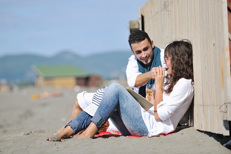 happy young couple enjoying  picnic on the beach and have good time on summer vacationsの写真素材