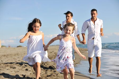 happy young family in white clothing have fun at vacations on beautiful beach の写真素材