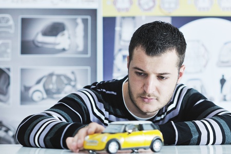 young businessman car designer posing indoor in casual clothing over big bright window
