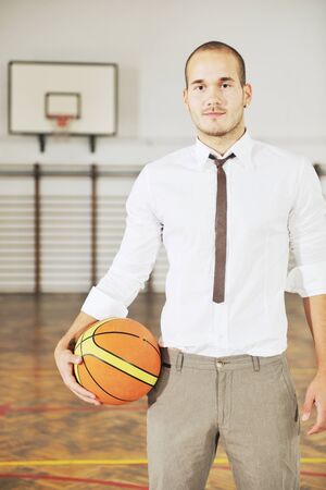 young business man basket player hold basketball ball and representing success and retirement in sport like also sports management conceptの写真素材