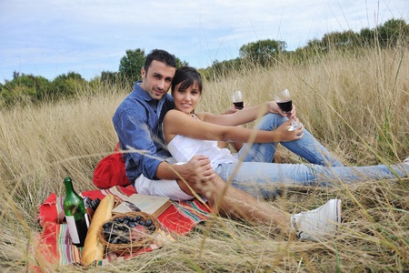 happy young couple enjoying  picnic on the countryside in the field  and have good timeの写真素材