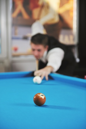 young pro billiard player finding best solution and right angle at billard or snooker pool sport ...