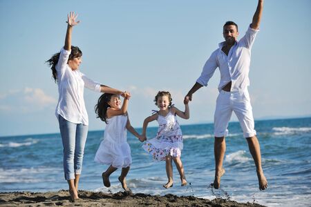 happy young family in white clothing have fun at vacations on beautiful beach の写真素材
