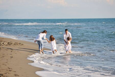 happy young family in white clothing have fun at vacations on beautiful beach の写真素材