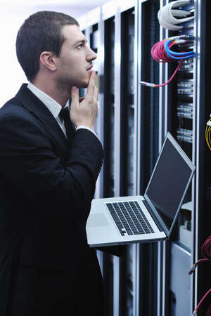 young engeneer business man with thin modern aluminium laptop in network server room