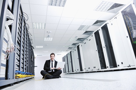 young engeneer business man with thin modern aluminium laptop in network server room