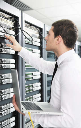 young it  engeneer business man with thin modern aluminium laptop in network server roomの写真素材