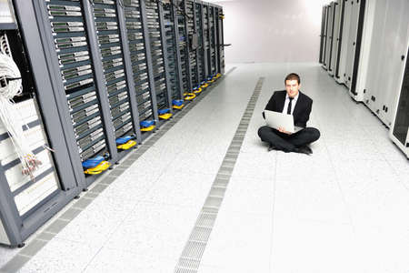 young it  engeneer business man with thin modern aluminium laptop in network server room