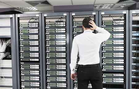 it business man in network server room have problems and looking for  disaster situation  solutionの写真素材