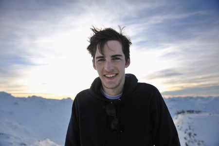 happy young man have fun at  mountain peak on winter season with beautiful sunset の写真素材