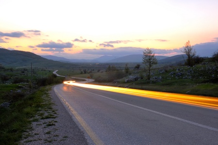 landscape in nature and countryroad adventure with beautiful sunset and dramatic clouds and skyの写真素材