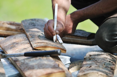 manual wood worker wirking with chainshaw closeup