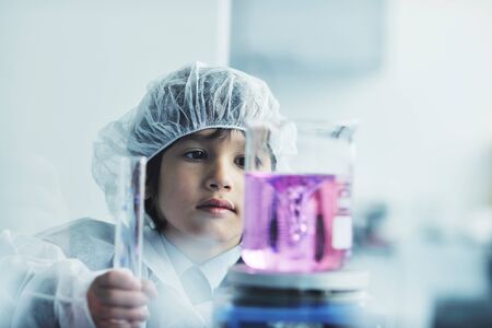 cute little male child have experiment with test tubes in bright modern labの写真素材