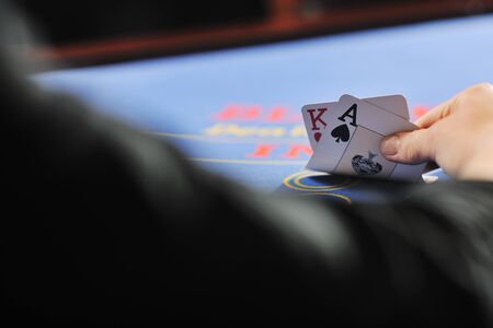 woman play black jack card game in casino on blue table