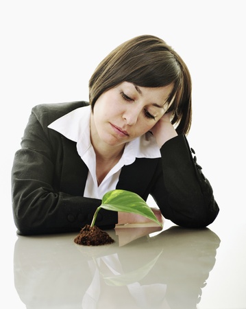 young business woman isolated on white holding green plant with small leaf and waiting to growの写真素材