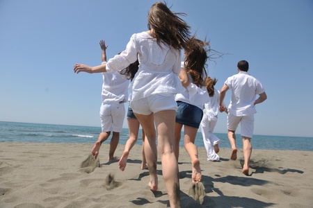 happy people group have fun  run and jump  on beach beautiful sand  beachの写真素材